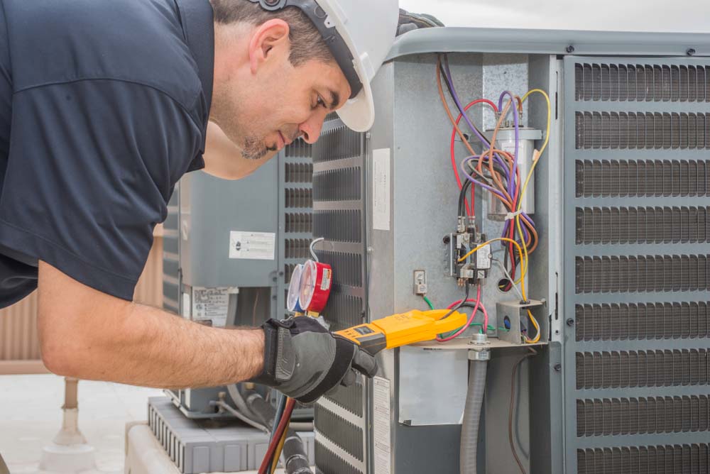 Technician tinkering with an HVAC system Sarasota, FL