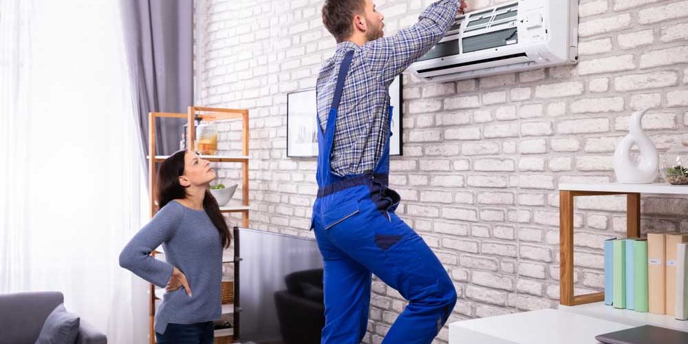 Technician tinkering with the electronic components of an AC system